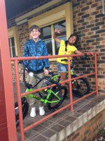 2 kids receive their team building bikes