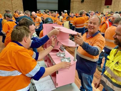 Hunter Valley Operations mini staff in full flouro gear complete a superb large group 400 + staff Charity giving back to local community team building Children's Toys. Is the best rewarding staff fun large group team activity to celebrate and connect. Lets make it superb!